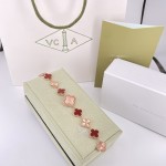 Van Cleef & Arpels watch with a rose gold dial featuring red mother-of-pearl clover motifs.